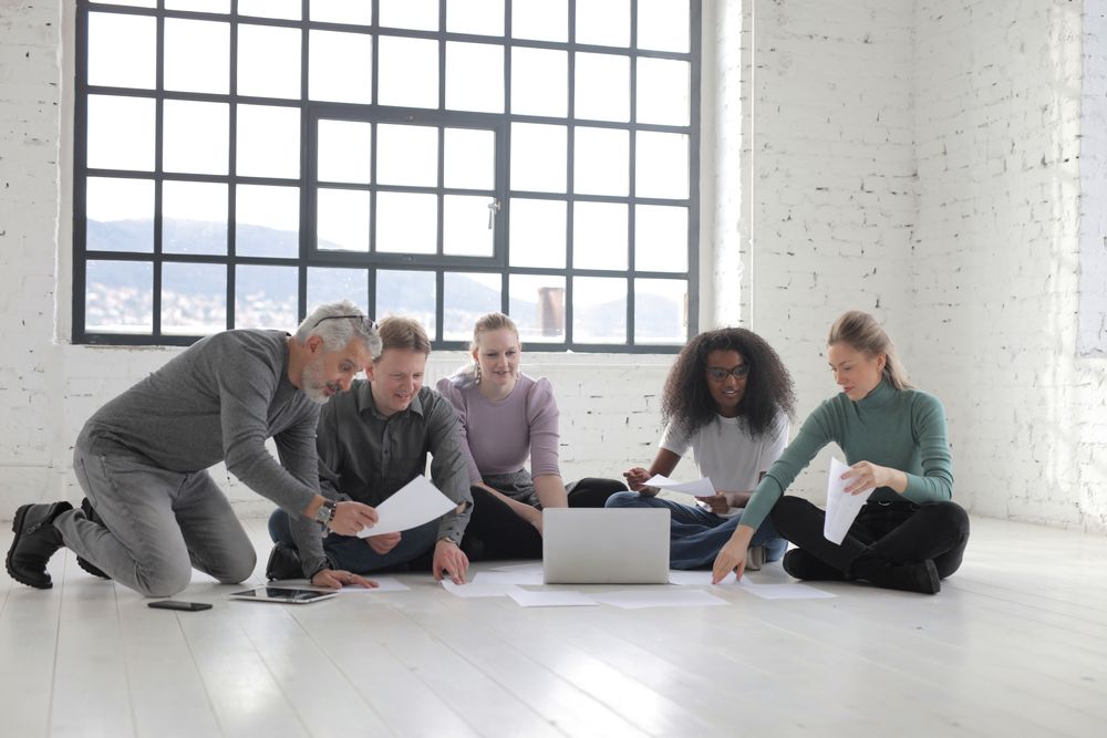 Equipe trabalhando em notebooks ao redor de uma mesa
